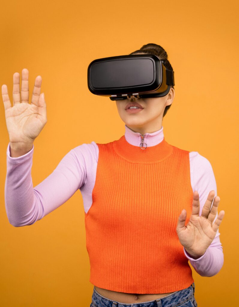 Adult woman immersed in VR technology, wearing a headset against a vibrant orange background.